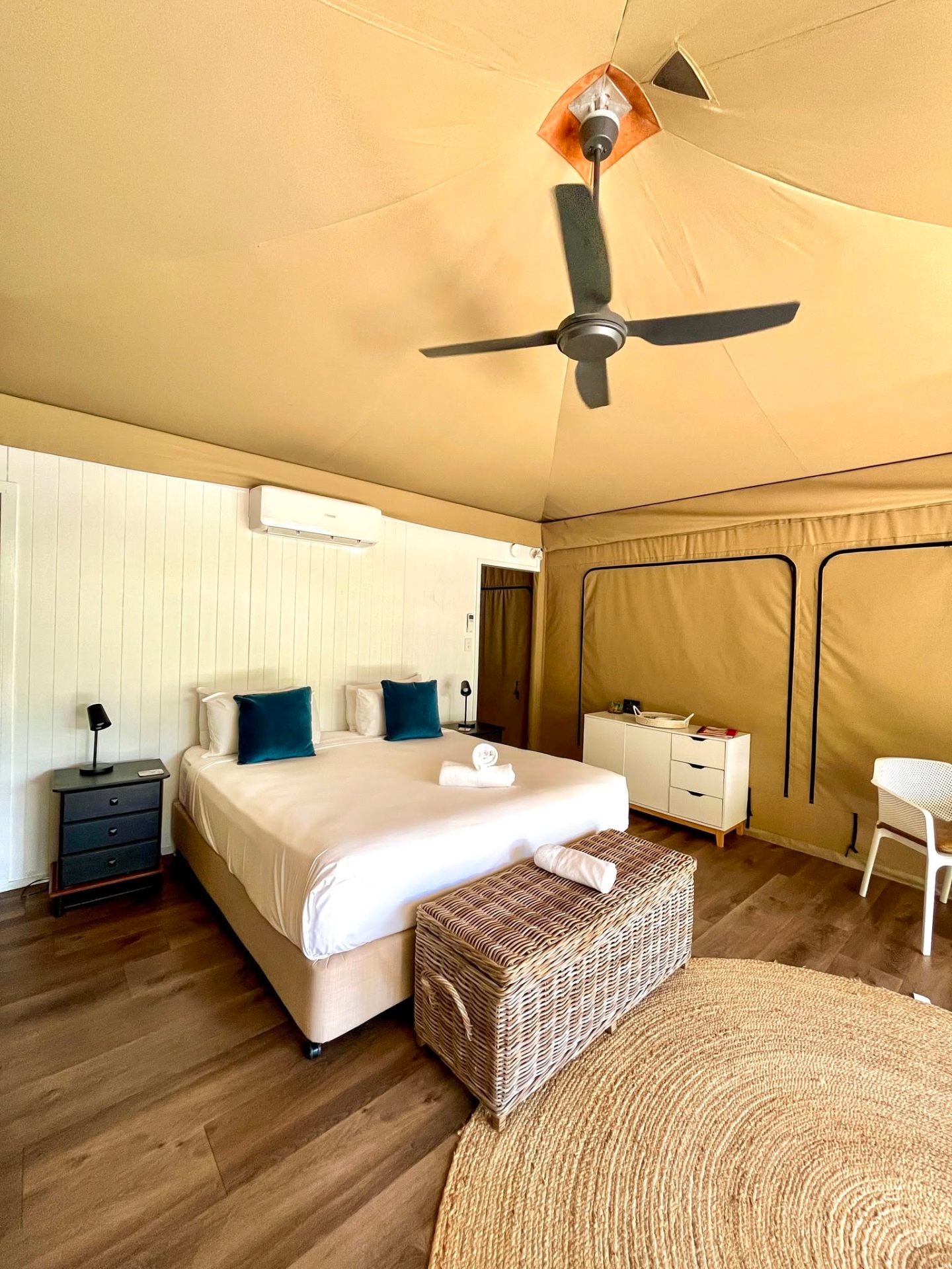 Inside a Magnetic Glamping canvas tent with king bed and ceiling fan