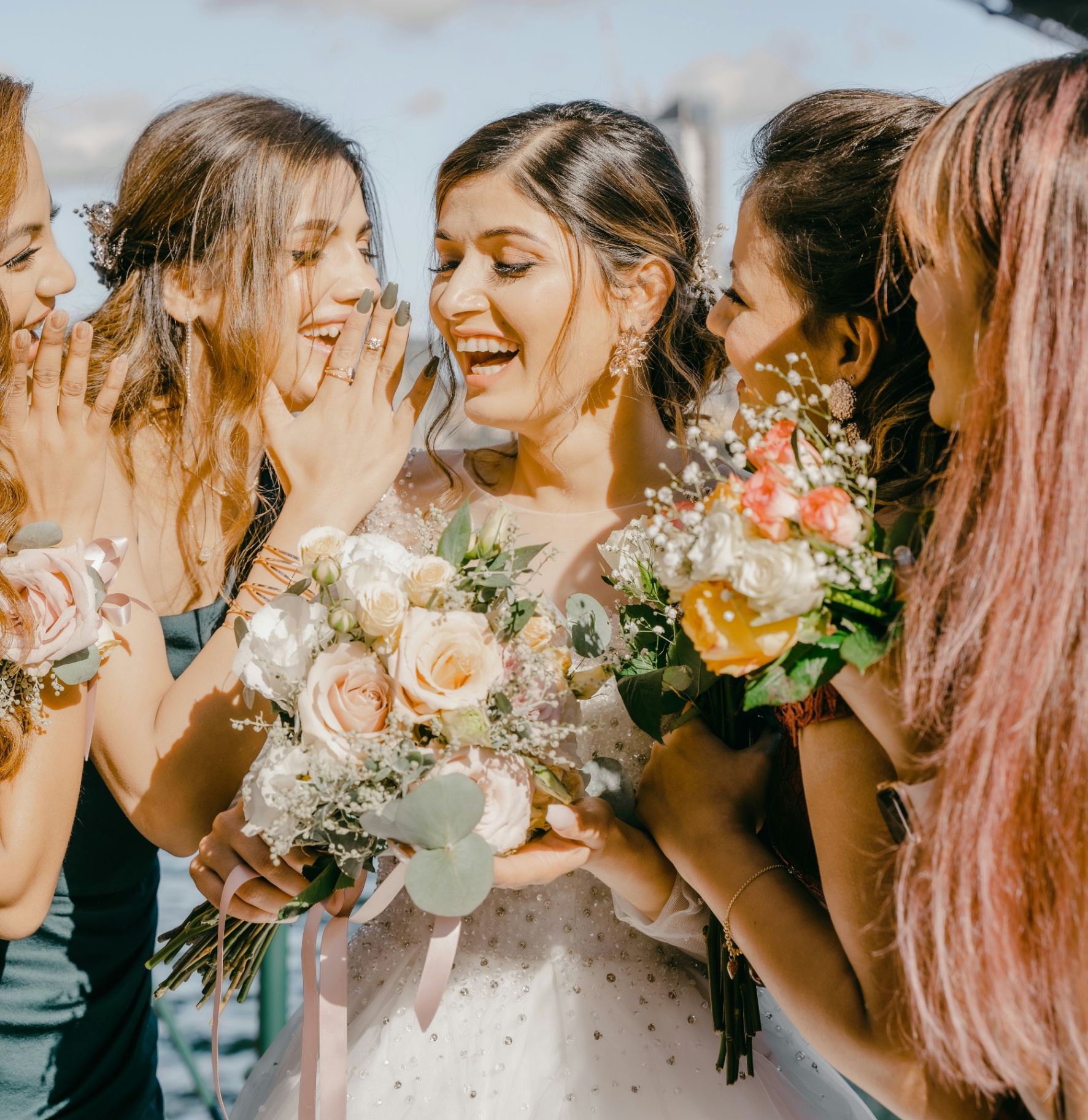 Bride laughing with friends on the water