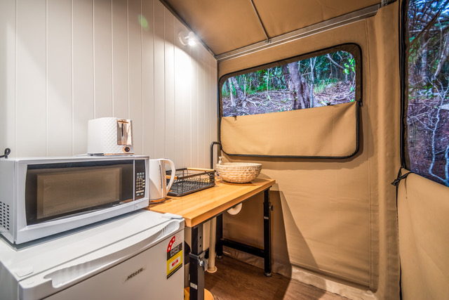 Kitchenette inside a Magnetic Glamping safari lodge — fridge, kettle, essentials