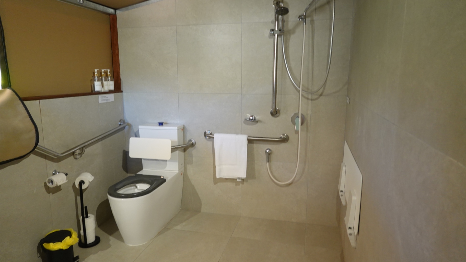 The Tent 7 accessible ensuite — wide wet-room shower and stainless grab rails