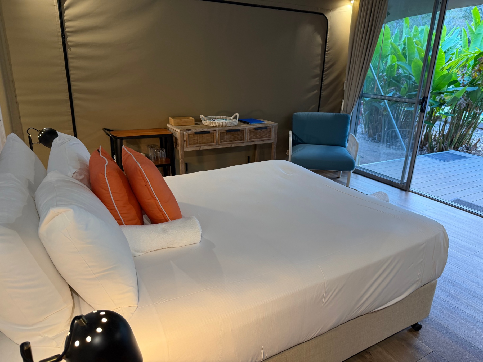 King bed looking out to the private timber deck and tropical garden, Magnetic Glamping