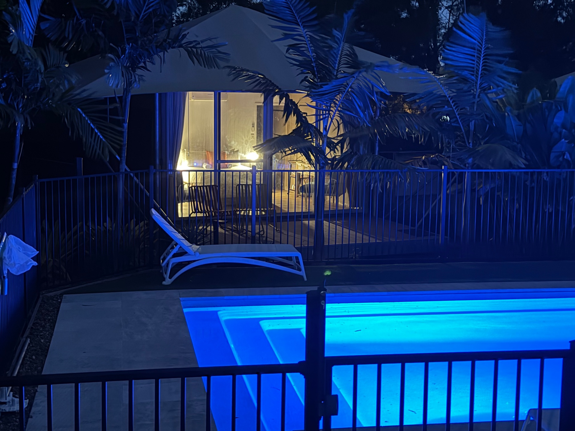 Tent 10 glowing at dusk with the pool nearby, Magnetic Glamping